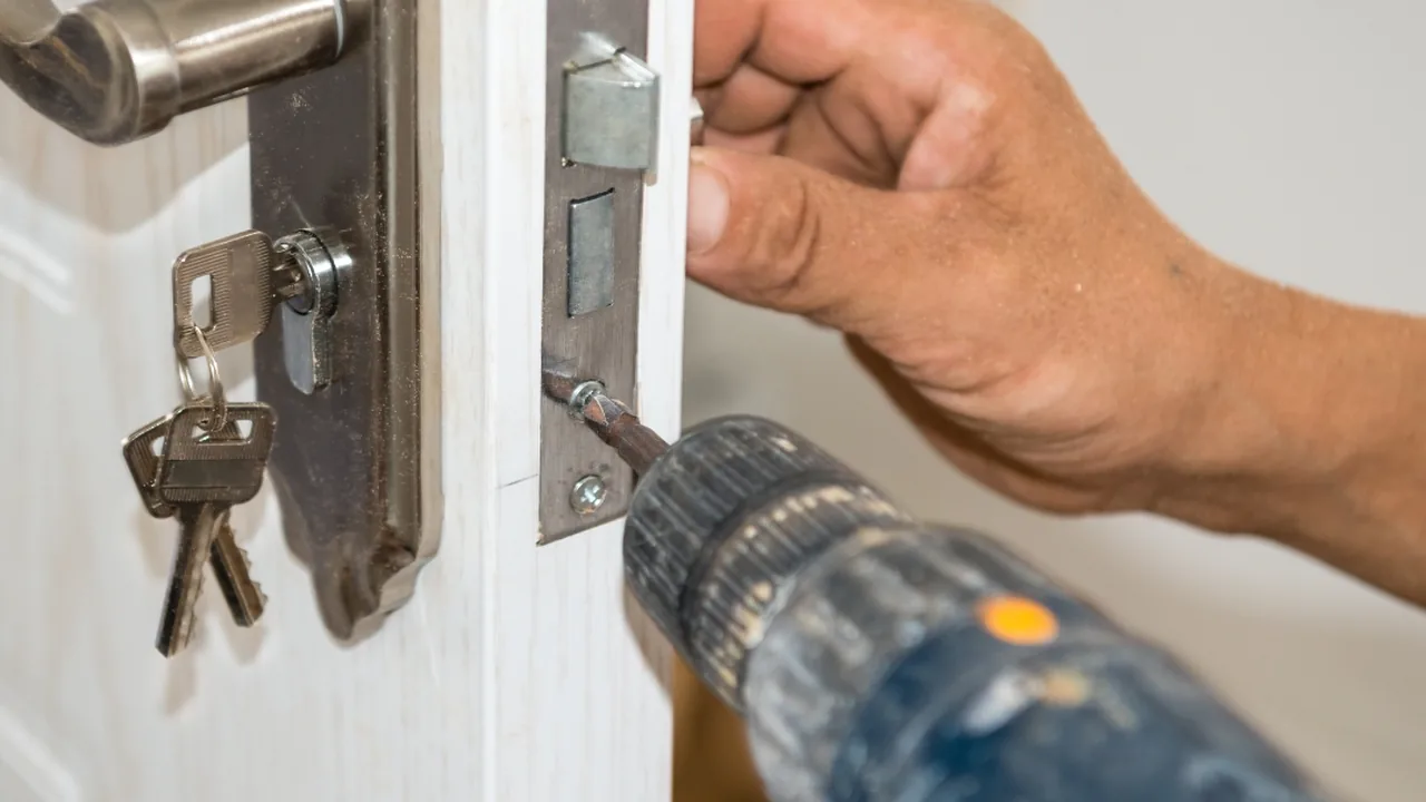 A Locksmith Stockton technician changing a lock at a customer's door